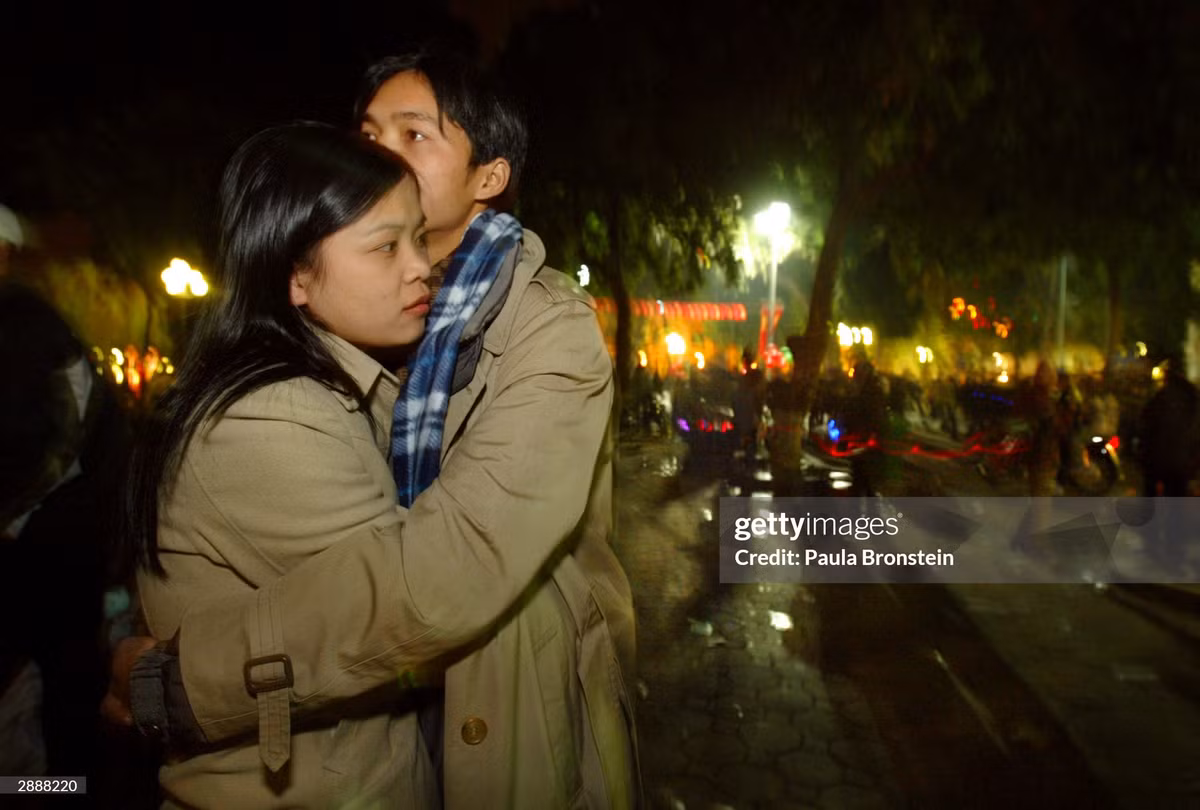 Cặp đôi ôm nhau ở bờ hồ trước thời khắc giao thừa.