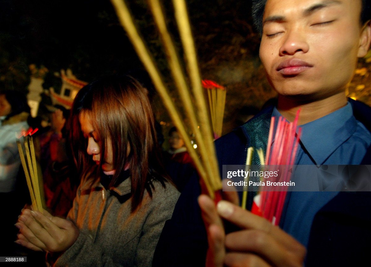 Người dân thắp hương và đốt vàng mã ở lối vào đền Ngọc Sơn.