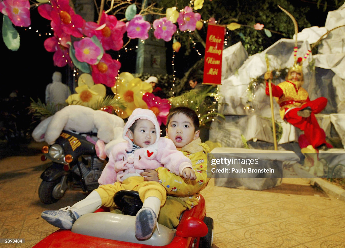 Hai em bé chụp ảnh ở bờ hồ.