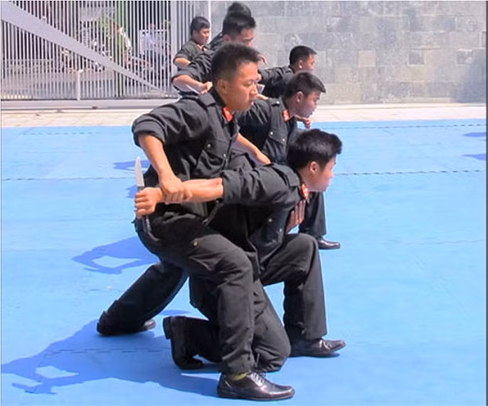 Tay không khống chế đối phương dùng dao.