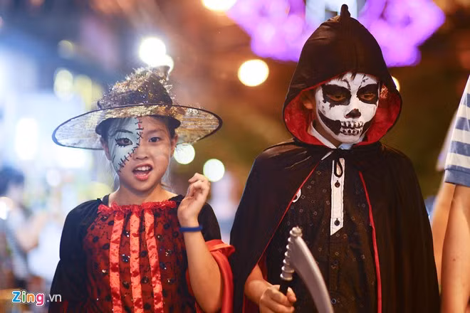 Một số bạn nhỏ hoá trang thành tử thần và phù thuỷ đi bộ trên phố Hàng Buồm.