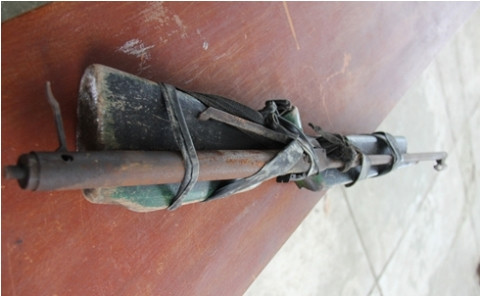 Bộ phận cò của khẩu súng tự chế có nòng là ống sắt được nẹp vào một phần của súng thật đã hư hỏng.