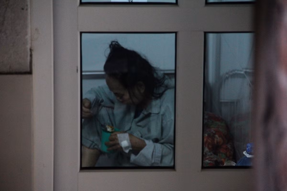 Không được ngồi cùng gia đình ăn bữa cơm đoàn viên trong ngày Tết, một bệnh nhân cúi mặt, rưng rưng nước mắt đưa từng miếng cháo lên miệng.