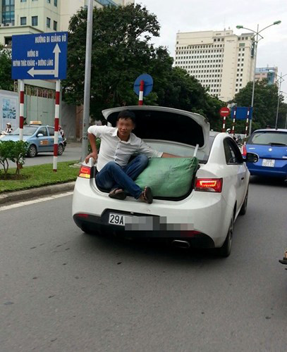 Người đàn ông liều mình ngồi sau cốp ô tô... giữ đồ.