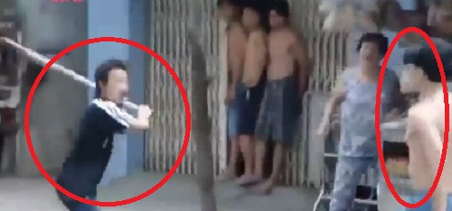 Hai nhân vật chính (khoanh đỏ) cầm gậy, dao rượt đuổi chém nhau gây náo loạn khu chợ.