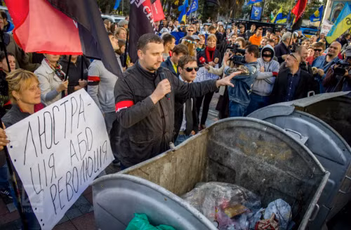 Đám đông phản đối tụ tập trước khi quan chức nào đó bị ném vào thùng rác