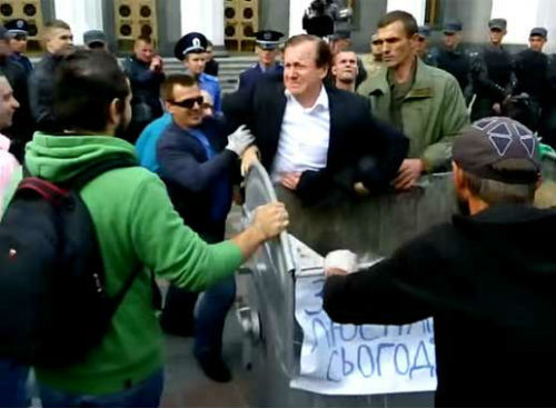 Một quan chức chuẩn bị bị ném vào thùng rác dù đã cố chống cự