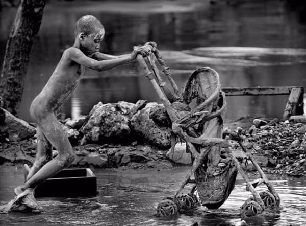 Cậu bé người Haiti cố gắng lượm lặt được một chiếc xe đẩy sau khi siêu bão Hannah tàn phá nơi này năm 2008.