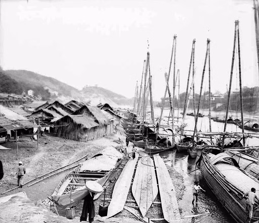 Thuyền của người Hoa bên bờ sông Hồng. Đây là loại thuyền có cột buồm cao làm bằng các thanh tre ghép lại. Khi thuyền neo đậu ở bến, những tấm buồm được hạ xuống và xếp dọc theo bờ sông.