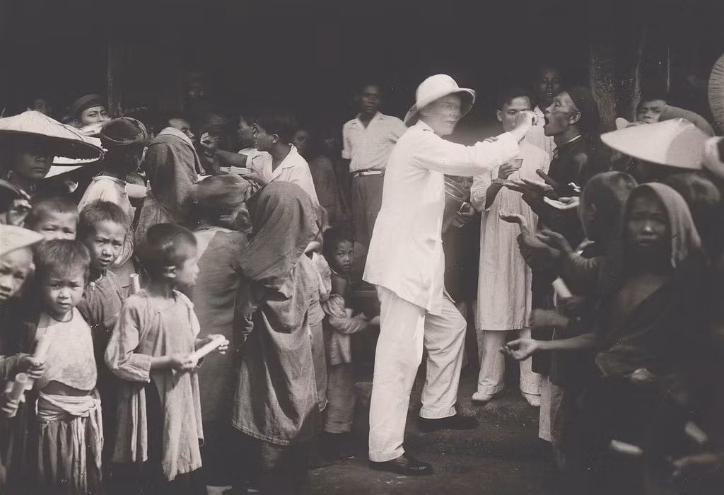 Các bác sĩ phát thuốc ký ninh chống sốt rét cho dân chúng.