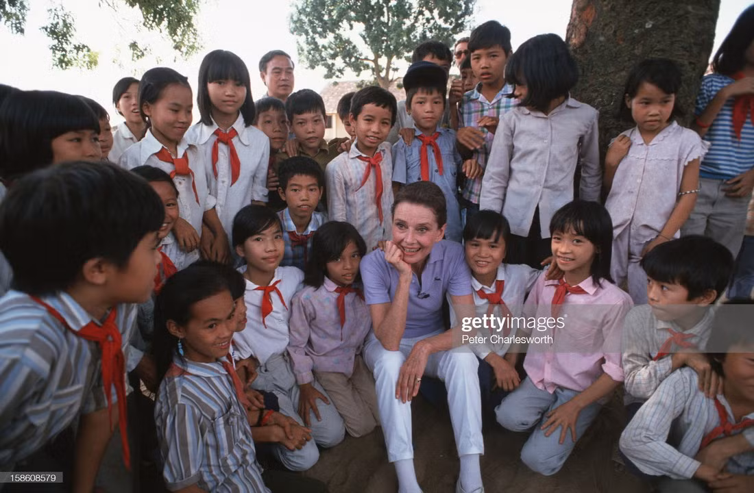 Cựu nữ minh tinh - Đại sứ thiện chí UNICEF Audrey Hepburn giao lưu với các học sinh tại một trường học do UNICEF tài trợ ở ngoại thành Hà Nội, 1/10/1990. Chuyến thăm Việt Nam của bà nằm trong khuôn khổ chương trình nước sạch nông thôn và vệ sinh môi trường của UNICEF. Ảnh: Peter Charlesworth/ LightRocket/ Getty Images.