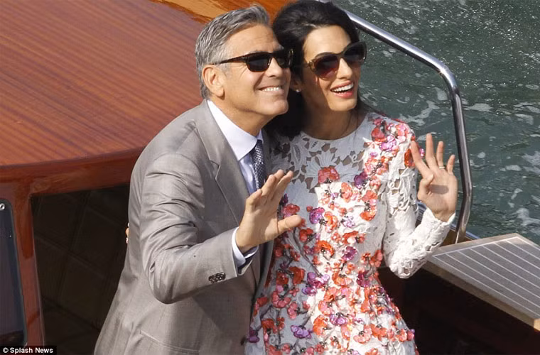 Hai vợ chồng Clooney vui vẻ vẫy tay chào người hâm mộ.