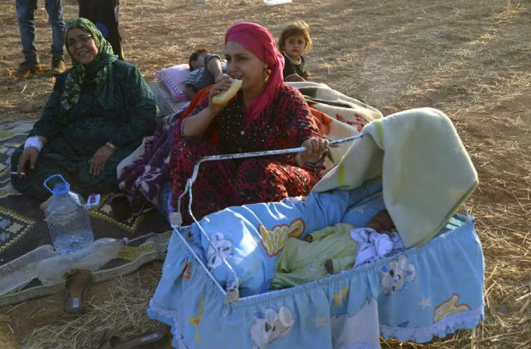 Em bé Syria nằm trong nôi bên canh gia đình ở biên giới Thổ Nhĩ Kỳ.