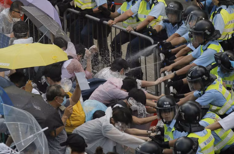 Cánh sát Hồng Kông xịt hơi cay vào người biểu tình.