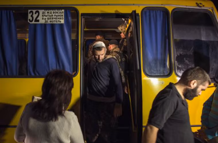 Tù binh của lực lượng ly khai xuống xe buýt trước khi trao đổi.