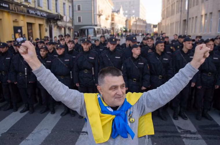 Một người biểu tình phản đối Moscow đứng trước lực lượng cảnh sát.