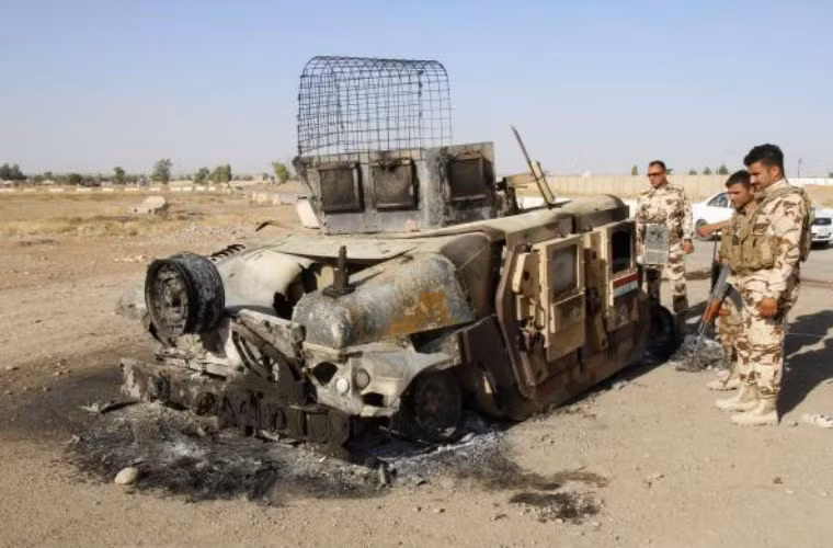 Các thành viên lực lượng an ninh Kurdish bên cạnh xe quân sự của Quân đội Iraq bị phiến quân tiêu diệt.