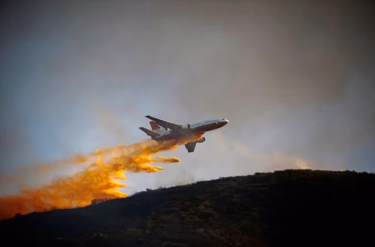 Máy bay DC-10 Super Tanker thả chất chống cháy xuống khu vực chưa bị cháy rừng ở gần thành phố San Marcos ngày 14/5.