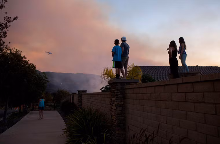 Người dân theo dõi lính cứu hỏa chiến đấu với đám lửa ở thành phố San Marcos.