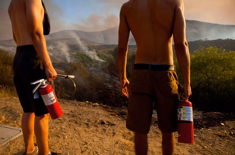 Sinh viên từ trường ĐH Bang California, San Marcos nhìn khói bốc lên từ các ngọn cây sau khi lính cứu hỏa dập tắt đám cháy ở gần đó.