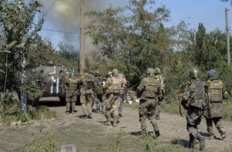 Binh sĩ Ukraine theo sau xe bọc thép ở thành phố miền đông Ilovaysk.