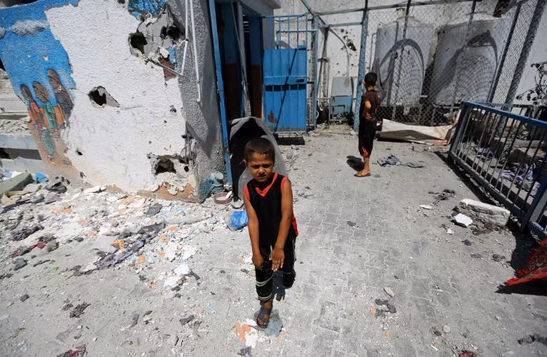 Trẻ em Palestine chơi gần một ngôi trường của Liên Hiệp Quốc bị trúng pháo kích.