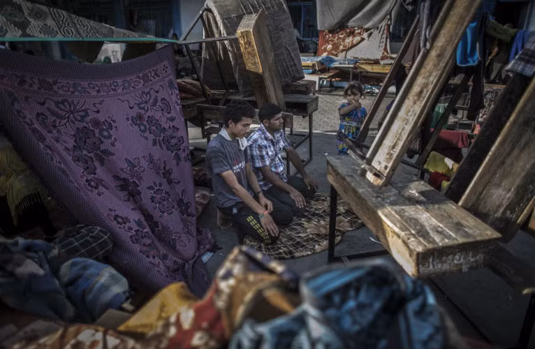 Người dân Palestine cầu nguyện trong một trường học tại khu tị nạn của Liên Hiệp Quốc.