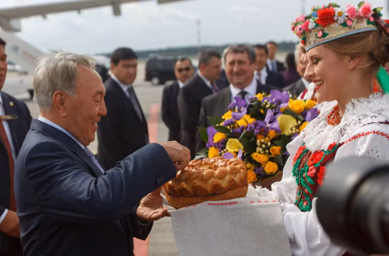Tổng thống Kazakhstan Nursultan Nazarbayev thử bánh mỳ và muối sau khi xuống sân bay.