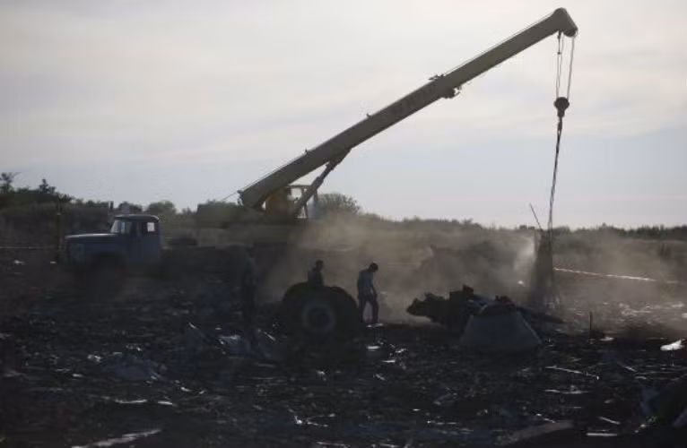 Nhân viên Bộ Khẩn cấp Ukraine dùng cần cẩu để di chuyển những mảnh vỡ máy bay MH17.