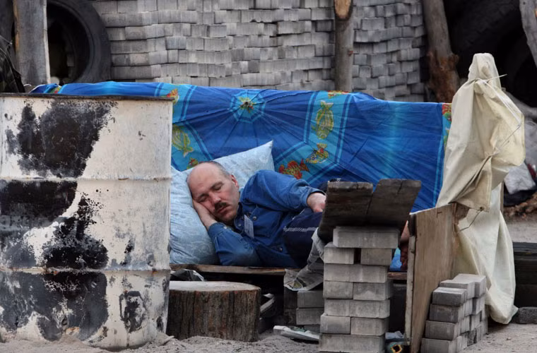 Một người biểu tình tranh thủ ngủ trên công sự ở thành phố Donetsk.