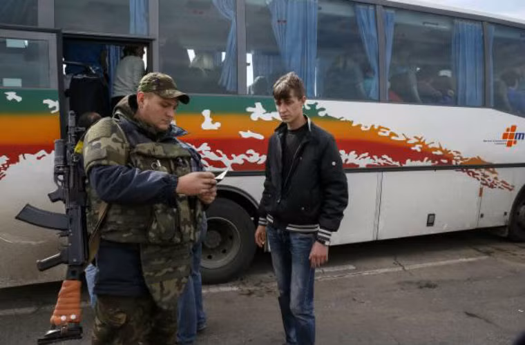 Binh sĩ Vệ binh Quốc gia Ukraine kiểm tra thẻ căn cước của 1 thanh niên ở Lugansk.