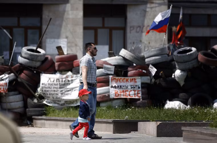 Hai cha con đi dạo bên ngoài tòa chị chính Donetsk.