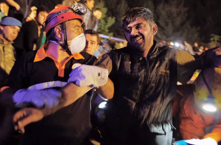 Đám đông đang hoan hô người thợ mỏ được cứu lên trên mặt đất.