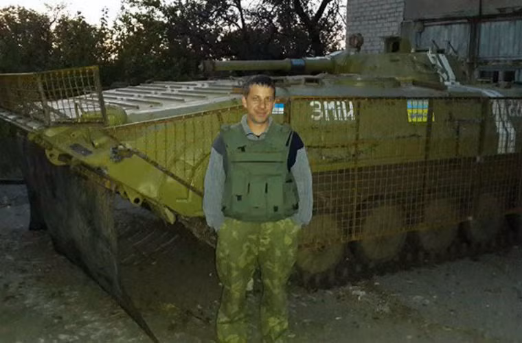 Tình nguyên viên chụp ảnh bên cạnh xe bọc thép của Quân đội Ukraine.