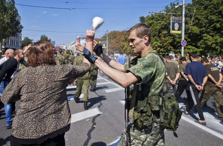 Người dân ném đồ vật về phía các binh sĩ Ukraine bị bắt giữ.