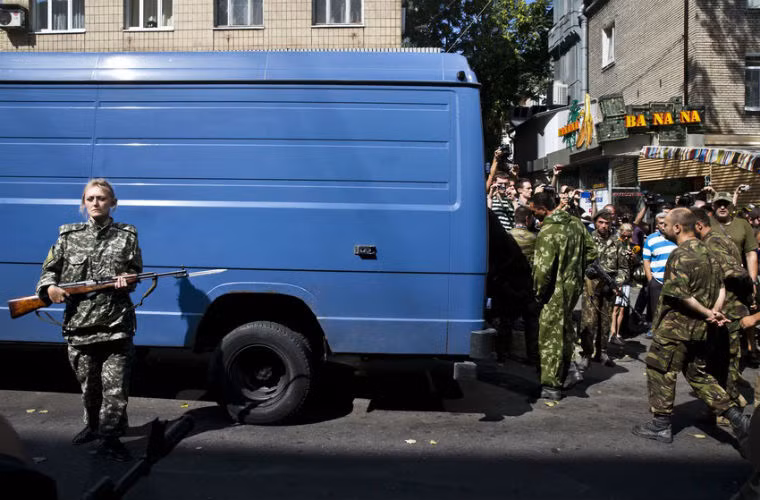 Nữ binh sĩ lực lượng ly khai áp giải tù binh diễu phố.