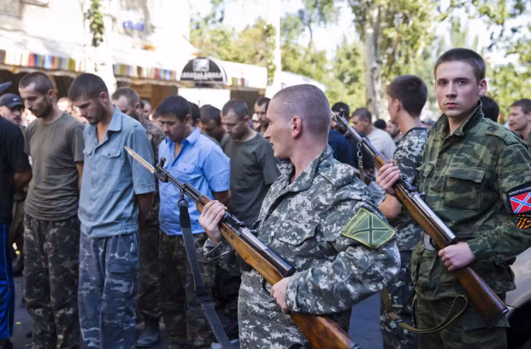 Binh sĩ lực lượng ly khai áp giải tù binh diễu phố.