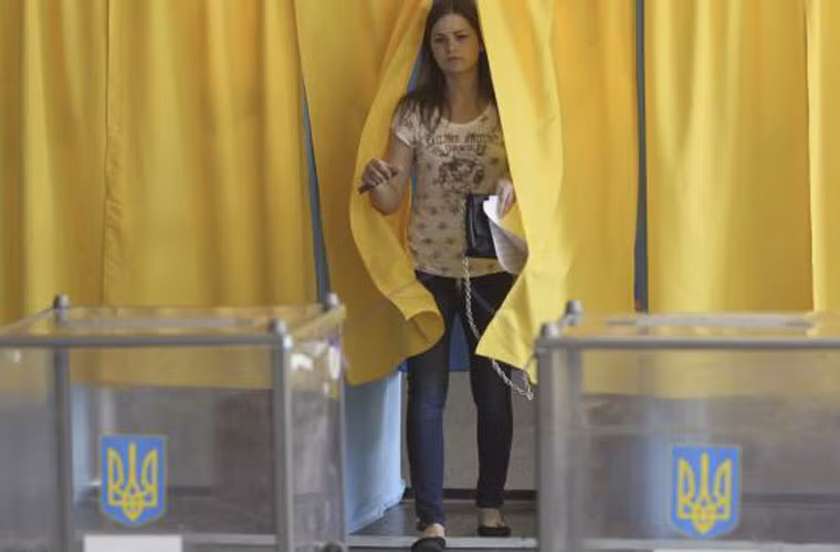 Một người phụ nữ rời quầy điền phiếu trước khi bỏ phiếu bầu cử Tổng thống Ukraine tại một điểm bỏ phiếu ở Dnipropetrovsk ngày 25/5.