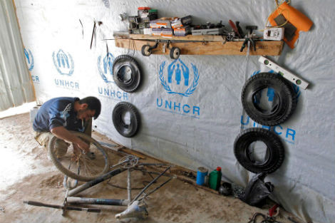 Một người tị nạn Syria đang sửa xe đạp ở cửa hàng của ông tại trại tị nạn cho người Syria tại Zattari, Jordan ngày 24/3/2014.