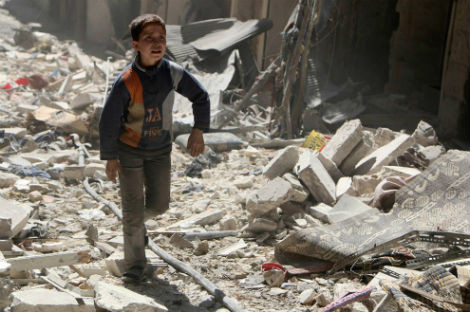 Cậu bé đi trên đống đổ nát ở khu vực mà theo lời quân nổi dậy bị quân chính phủ Syria không kích ở quận al-Sukari của Aleppo vào ngày 23/3/2014.