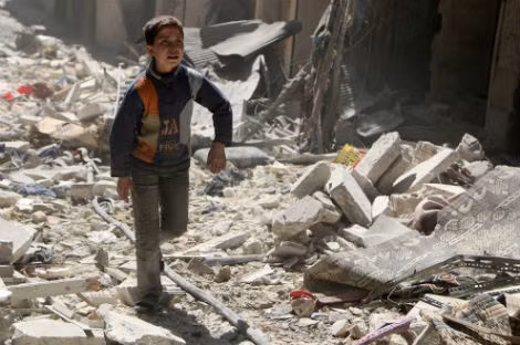 Cậu bé đi trên đống đổ nát ở khu vực mà theo lời quân nổi dậy bị quân chính phủ Syria không kích ở quận al-Sukari của Aleppo vào ngày 23/3/2014.