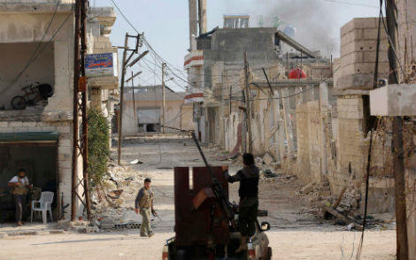 Phe nổi dậy Syria bên khẩu súng máy phòng không được lắp trên một chiếc xe tải ở thị xã Morek tỉnh Hama, ngày 21/3/2014.