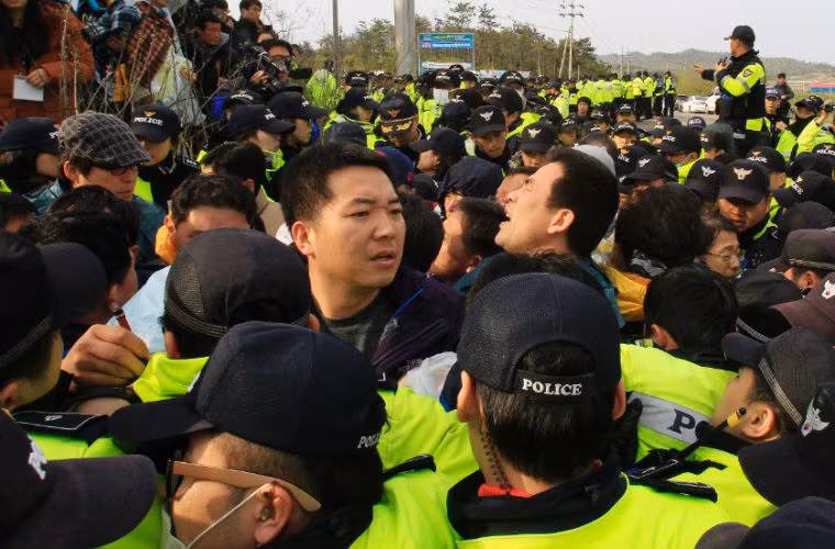 Thân nhân các nạn nhân của vụ chìm phà Sewol đấu tranh với cảnh sát trên đảo Jindo khi họ định tuần hành đến trước Phủ Tổng thống Hàn Quốc ngày 20/4 để phản đối chiến dịch tìm kiếm chậm chạp.