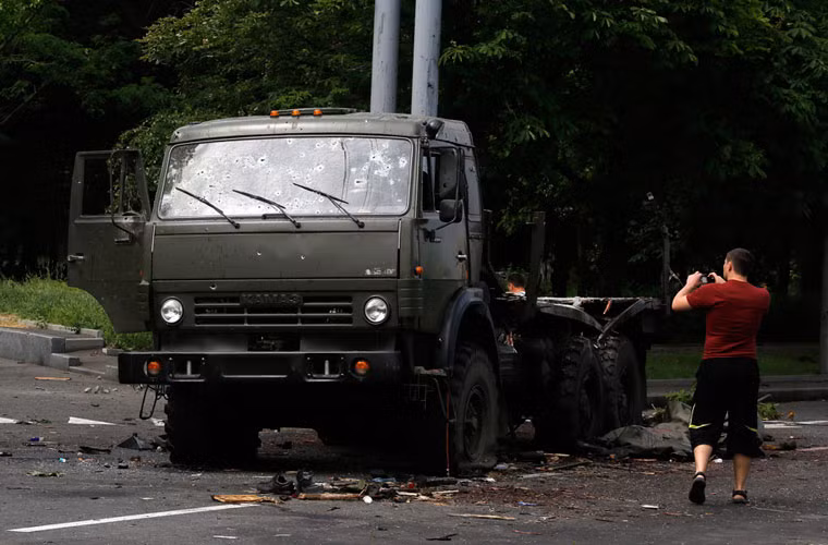 Người dân địa phương chụp ảnh chiếc xe vận tải Kamaz bị các lực lượng vũ trang Ukraine mai phục bắn hạ.