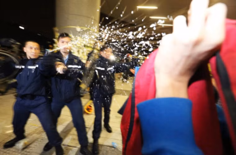 Một số người biểu tình quá khích bị cảnh sát dùng bình xịt hơi cay đẩy lùi.