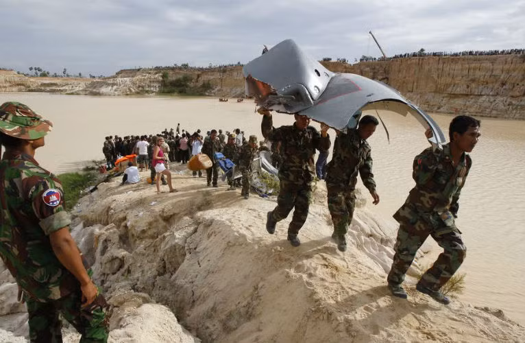 Quân nhân Campuchia mang các mảnh vỡ của trực thăng Z-9 lên bờ.