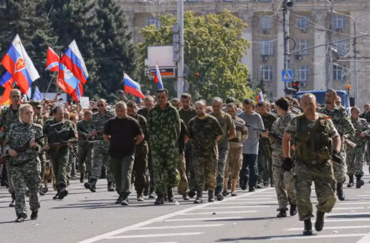 Các tù binh đi giữa 2 hàng lính của lực lượng ly khai.