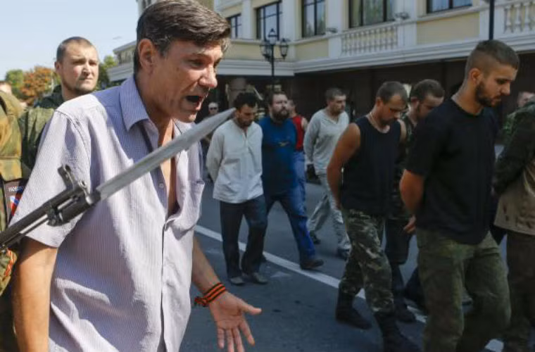 Một người dân đứng mắng những tù binh.