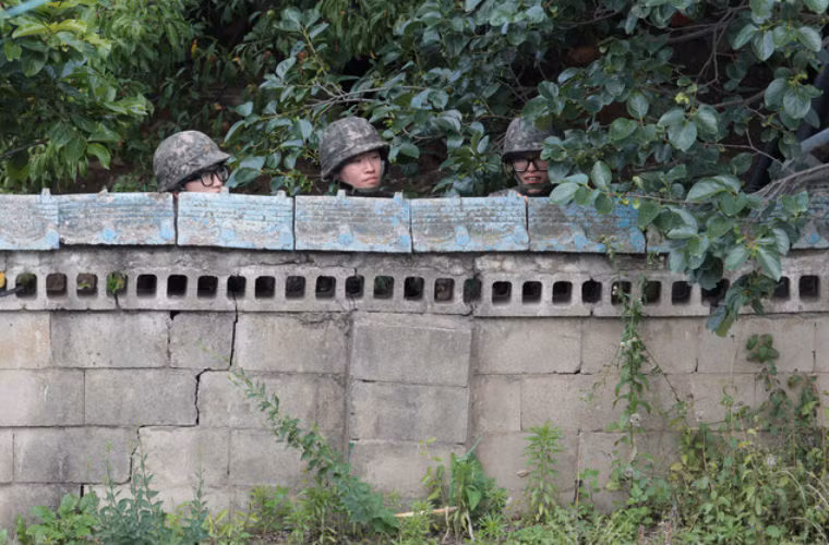 Các binh sĩ Hàn Quốc nấp sau 1 bức tường trong quá trình bao vây binh sĩ Yim.