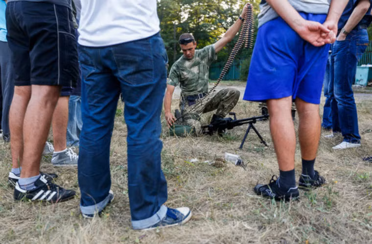 Thành viên tiểu đoàn tình nguyện Azov hướng dẫn người dân Mariupol tháo lắp đạn.